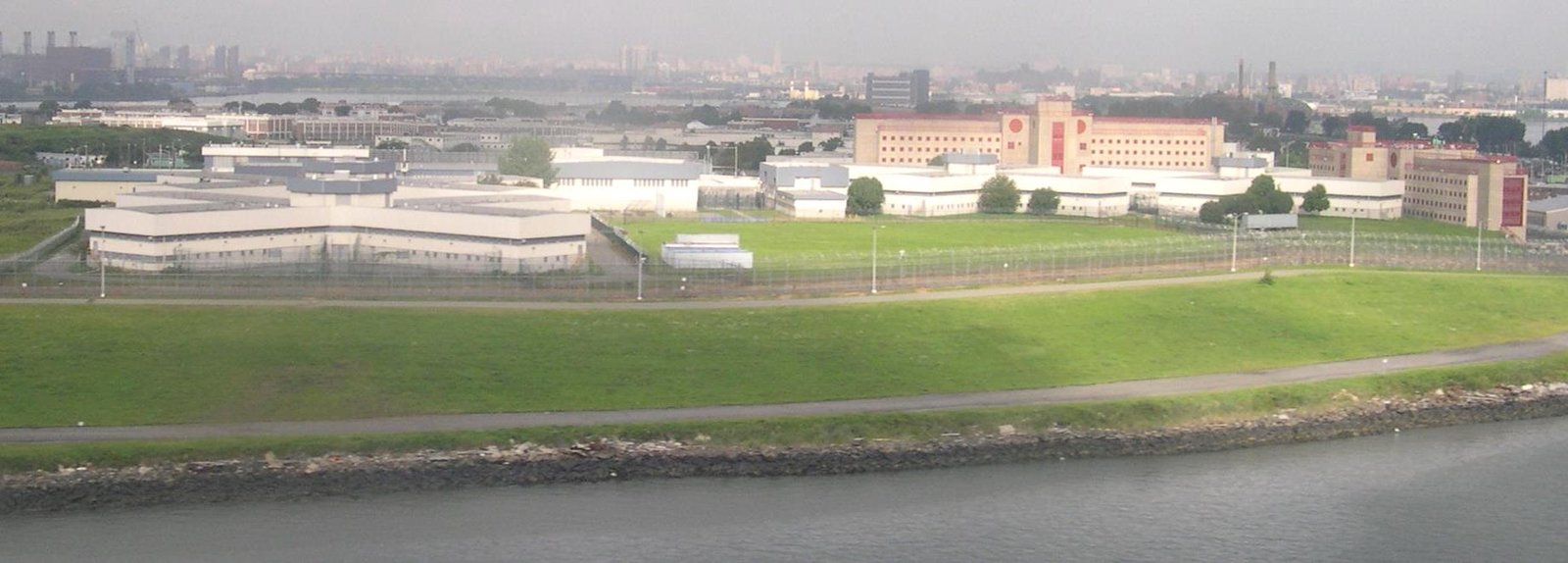 Aerial view of the Rikers Island jail complex with the Manhattan skyline in the distance