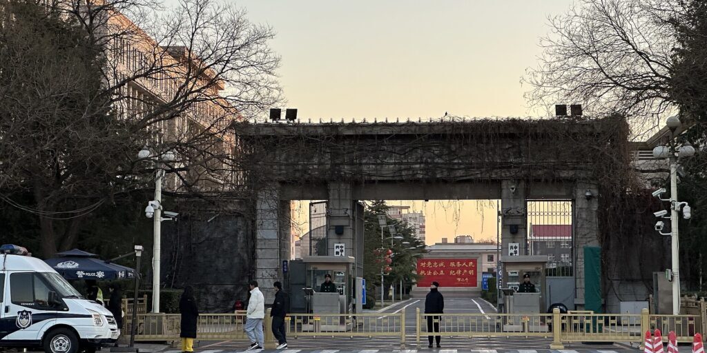 Police vehicles and officers at the entrance gate to a government ministry building