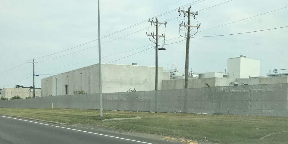 Industrial chicken processing facility with metal buildings and security fencing
