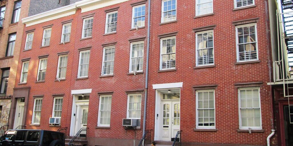 Greek Revival townhouses with red brick and white stone trim in West Village