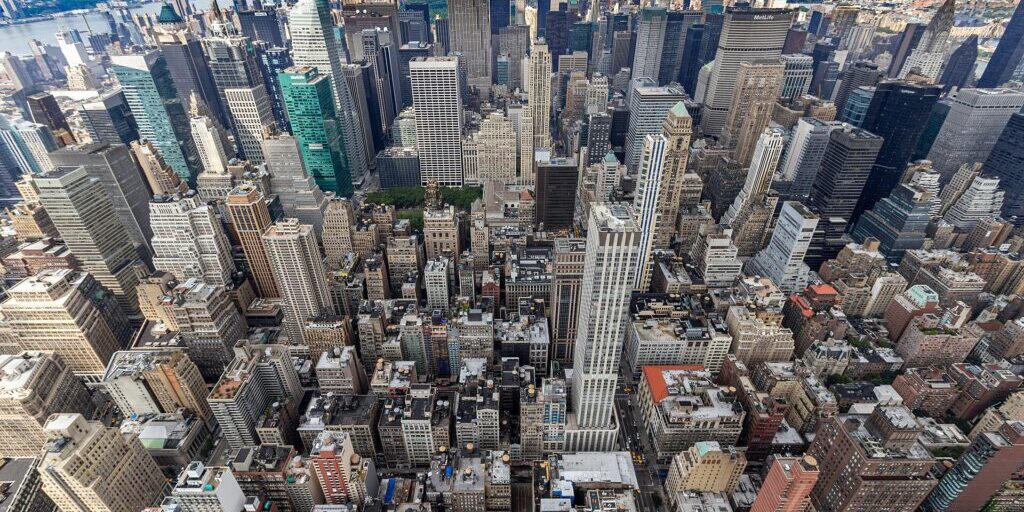 Aerial view of Midtown Manhattan's dense office buildings and city streets from above