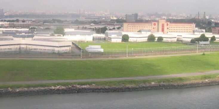 Aerial view of the Rikers Island jail complex with the Manhattan skyline in the distance